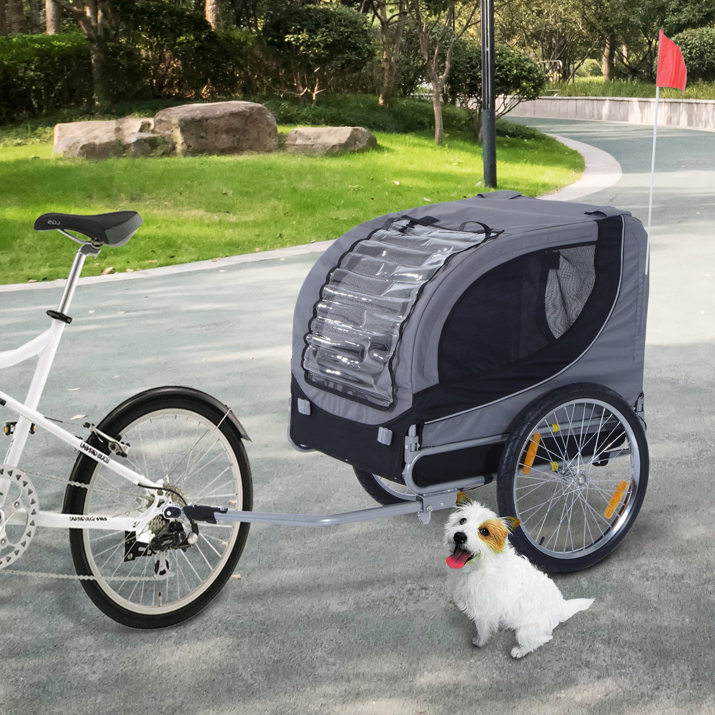 Image of gray Pet Bike trailer with a dog standing by it.